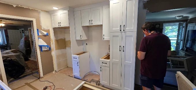 Custom white pantry cabinets being installed, showing clean mid-project workmanship