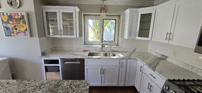 Corner sink kitchen with new white cabinet doors and quartz countertops